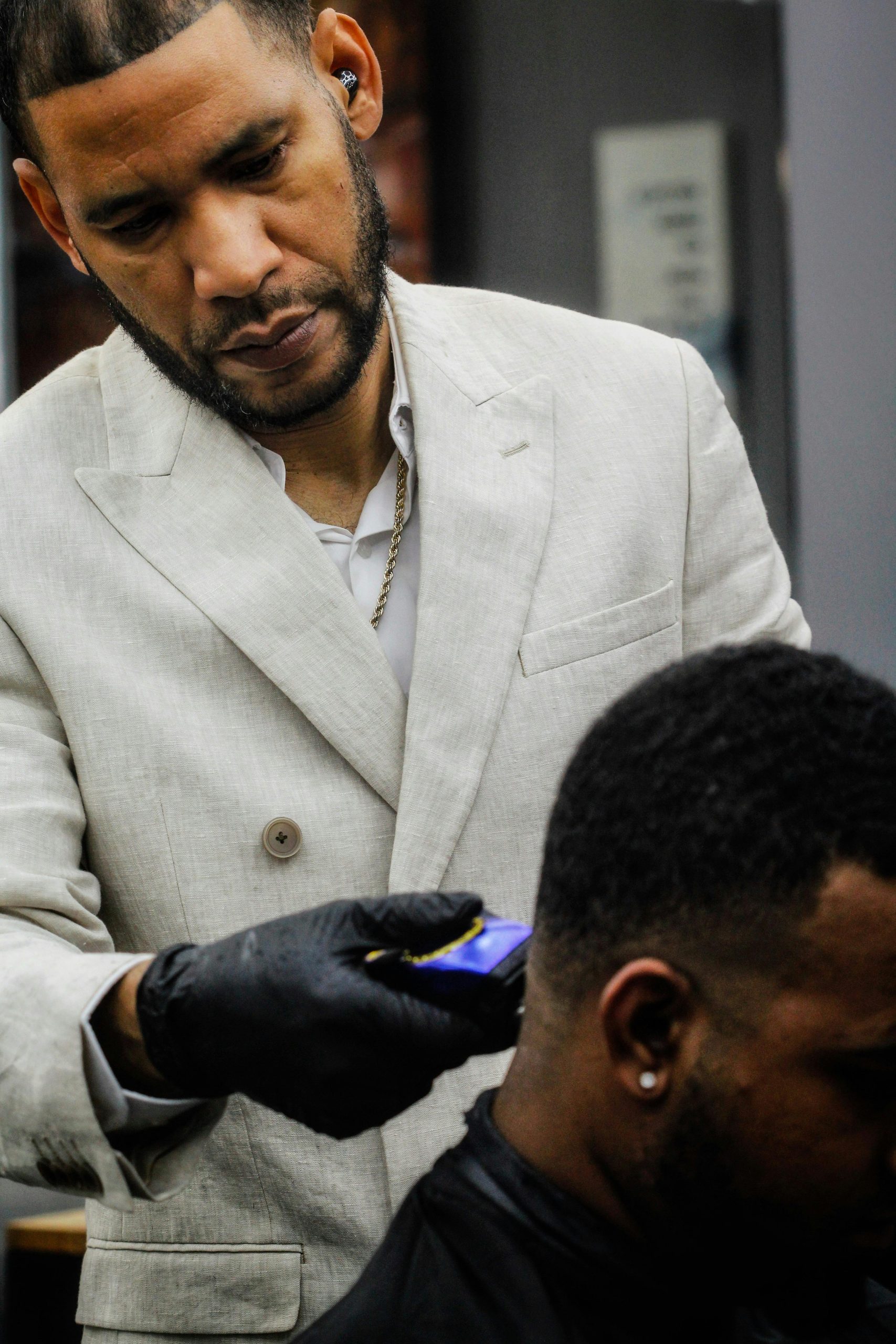Barber expertly using clippers to trim a client's hair in a modern salon environment.
