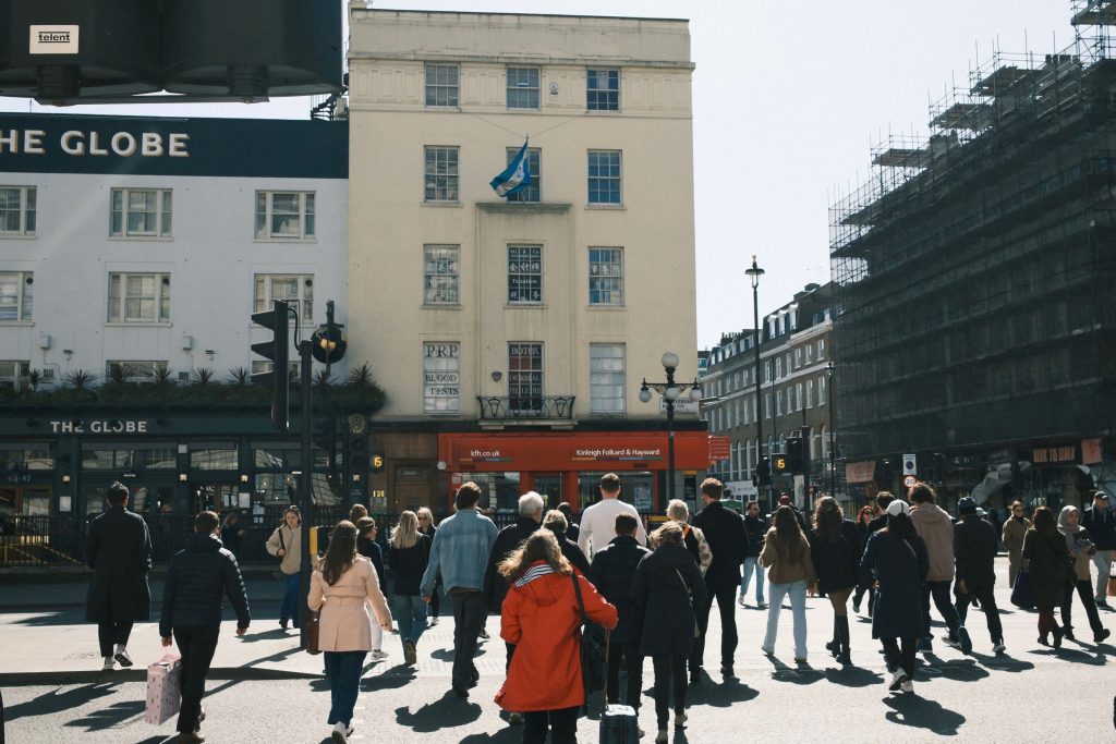 Urban scene in London with a diverse group of people crossing the street.